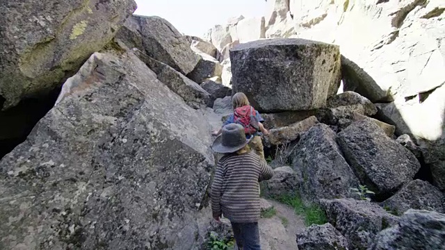 孩子们爬岩石穿过岩石峡谷视频素材