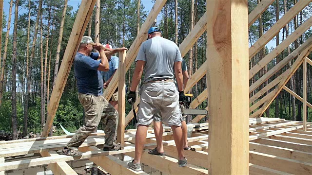 屋顶工人在屋顶上工作。建筑工人用锤子锤钉子。视频下载