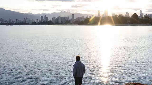 男人走过海湾，看到了城市的景色，日出视频下载