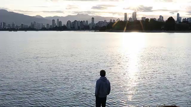 男人走过海湾，看到了城市的景色，日出视频下载