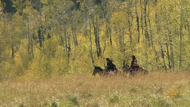 WS, TS，两个女人骑马在秋天的风景，圣胡安山脉的背景，科罗拉多州，美国视频下载