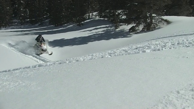 美国科罗拉多州圣胡安山，在粉状雪中驾驶雪地摩托的男子视频下载