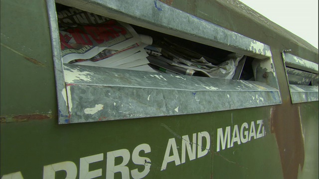 ZI, CU，将报纸放入回收箱的手，Ardley，牛津郡，英国视频下载