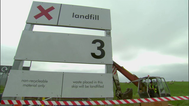 MS, LA，垃圾填埋场标志，背景中推土机中的男子，Ardley，牛津郡，英国视频下载
