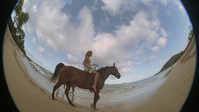 SLO MO，鱼眼，两个女人在海滩上骑马，毛伊岛，夏威夷，美国视频素材