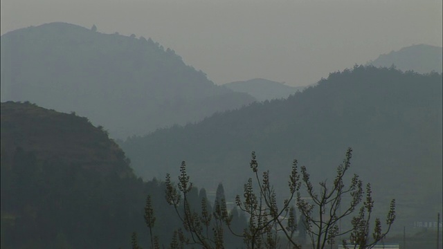 WS前景中有建筑的浓雾笼罩的山脉/中国贵阳视频素材