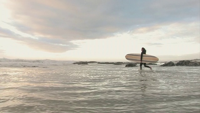 女子冲浪者运行与冲浪板在海洋，开普敦，西开普敦，南非视频素材