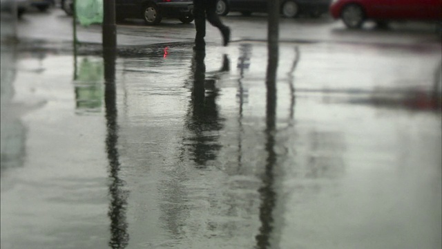 在雨天，法国巴黎潮湿的街道上，行人和自行车的倒影视频素材