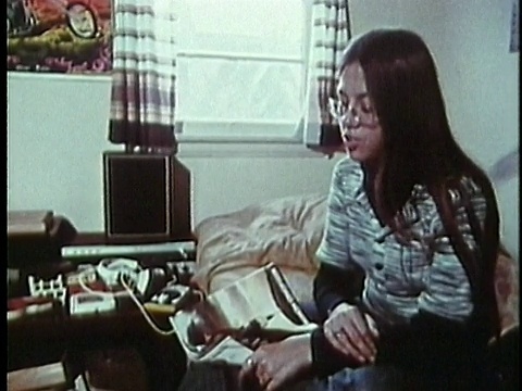 1973年，美国加州洛杉矶，一名十几岁的男孩和女孩在卧室里聊天视频素材