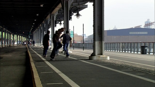 在FDR Drive / New York City下，长镜头滑板者表演特技视频素材