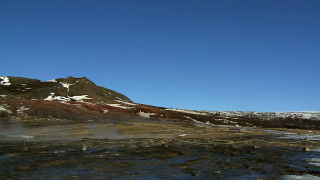 蒸汽腾腾的地热池、间歇泉喷出的水和蒸汽涌进空气/ Geysir，冰岛视频下载