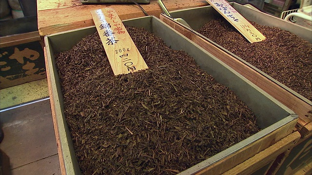 日本京都西贵市场的一名小贩正在用大木箱倒茶视频素材