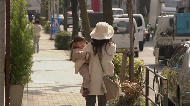 日本东京，一位女士带着女儿走在街上视频素材