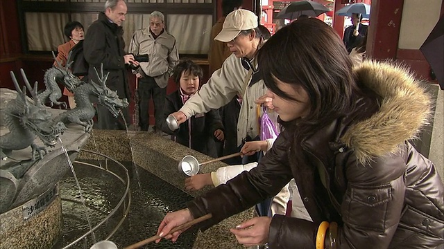 日本东京，人们在浅草寺喷泉洗手视频素材