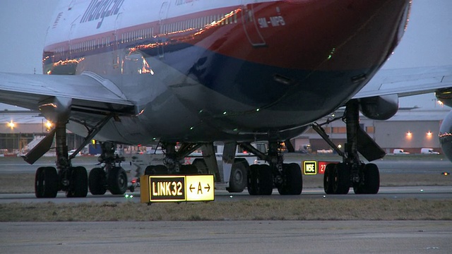 马来西亚航空公司波音747在英国伦敦滑行道上被拖拽视频素材