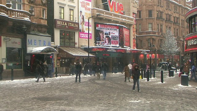 英国伦敦，被雪覆盖的莱斯特广场上的行人视频下载