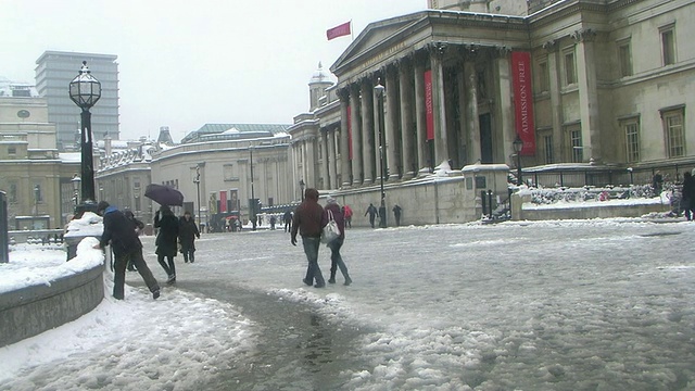 英国伦敦，特拉法加广场上白雪覆盖的行人，背景是国家肖像画廊视频下载