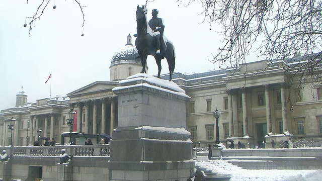 英国伦敦特拉法加广场，覆盖着白雪的乔治四世骑马雕像，背景是国家肖像画廊视频下载