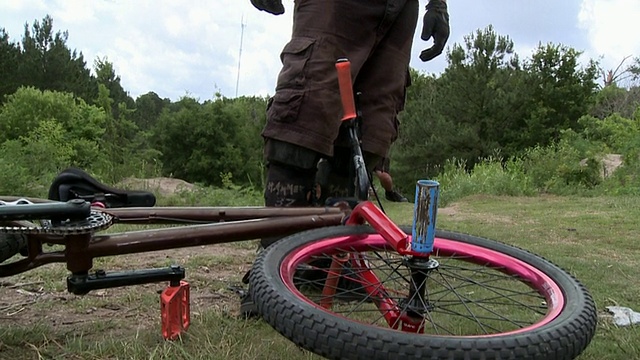 SLO MO MS TU PAN BMX摩托车手站在倒下的自行车/杰克逊维尔，佛罗里达，美国视频素材