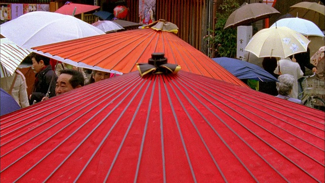 日本京都，人们撑着雨伞走在狭窄的街道上视频素材