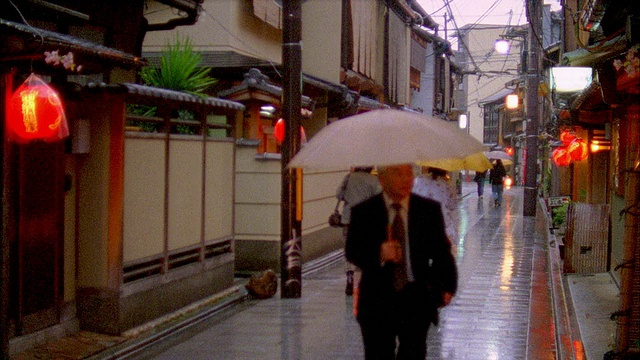 在日本京都，人们撑着雨伞走在狭窄的街道上视频素材