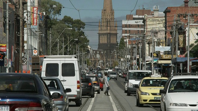 MS TU Traffic on Brunswick Street，背景是圣保罗大教堂塔，墨尔本，维多利亚，澳大利亚视频素材