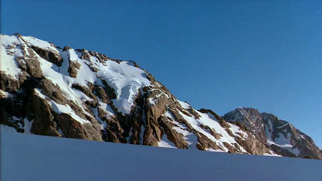 在新西兰库克山国家公园的山顶，白雪覆盖的斜坡投下了阴影视频素材