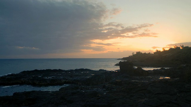 日落时海浪拍打着岩石海岸/考艾岛，夏威夷，美国视频素材