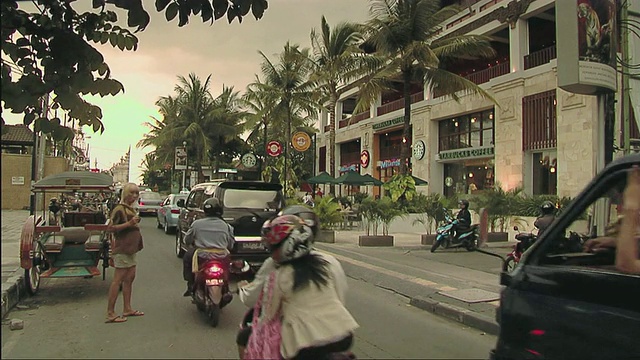 印度尼西亚巴厘岛，摩托车和汽车穿过城市街道视频下载