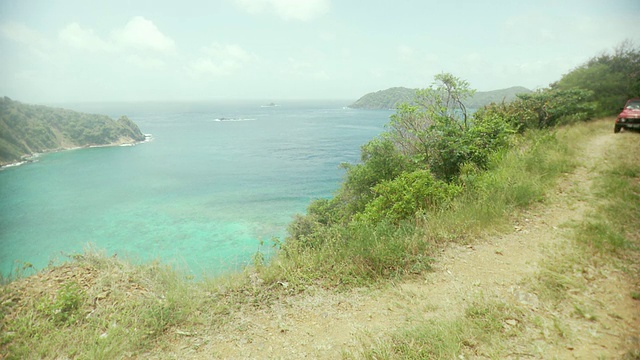 一对夫妇驾驶越野车驶过海洋/斯卡伯勒，多巴哥，特立尼达和多巴哥视频素材