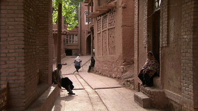 伊朗，Abyaneh，人们坐在屋外，女人走在小巷里视频素材