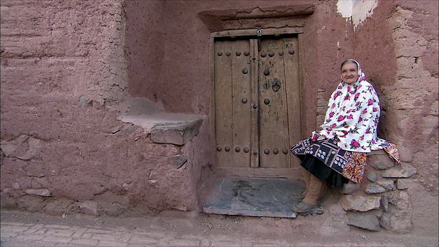 伊朗，Abyaneh，一名妇女坐在屋外视频素材