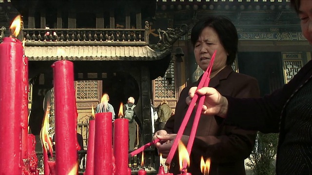 中国陕西西安，人们在寺庙外点燃蜡烛烧香视频素材