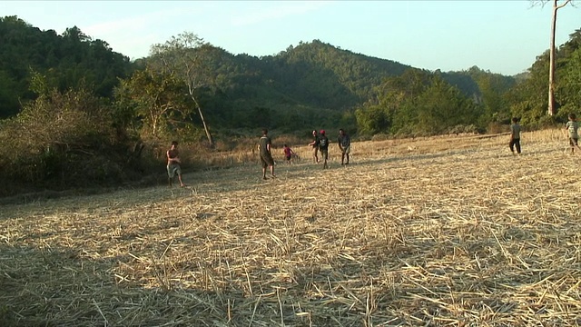 WS男孩在操场上踢足球，Pak Ou村庄，老挝视频素材