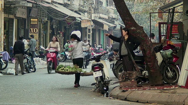 越南河内，一名妇女指着繁忙的街角视频素材