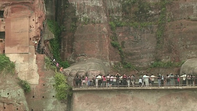 中国四川乐山，游客们在大佛前雕刻视频素材