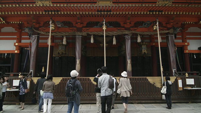 日本京都，祗园，八坂神社前捐钱和祈祷的人们的背影视频素材