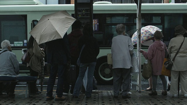 日本京都，在雨中的公交车站上的人们视频素材