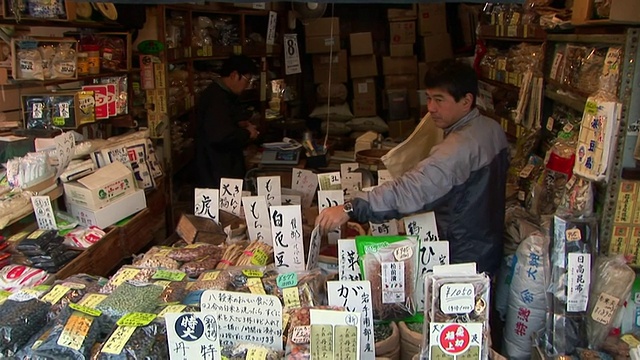 在东京筑地鱼市的摊位上，摊贩正在补充干货视频素材