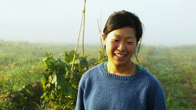 美国佛蒙特州曼彻斯特的有机农妇的画像，她站在田间，手里拿着装满蔬菜和狗的柳条篮子视频素材