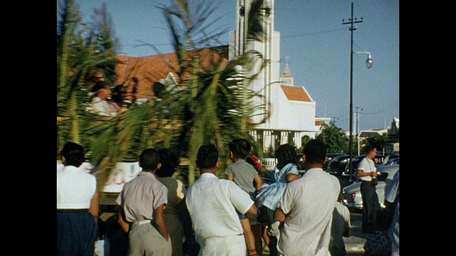 1954年家庭电影小安的列斯群岛阿鲁巴，人们在街上看着汽车和卡车经过视频下载