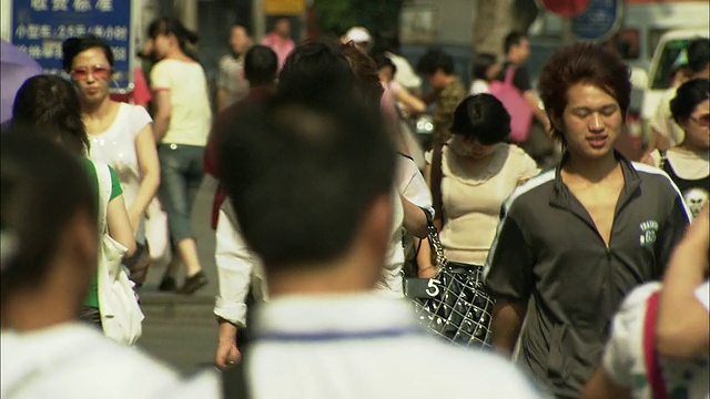 中国北京西单购物区拥挤的人行道上，一名年轻女子视频素材