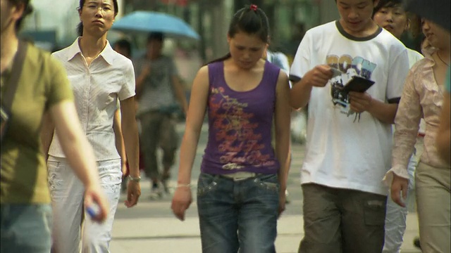 屠女士在北京西单购物区的人行道上选择性地聚焦人群视频素材