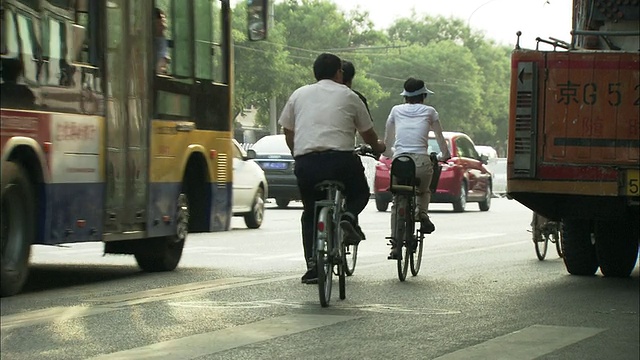 中国上海，街道上的汽车和骑自行车和摩托车的人视频素材