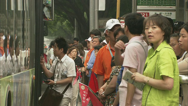 中国北京，人们在公共汽车站上公交车视频素材