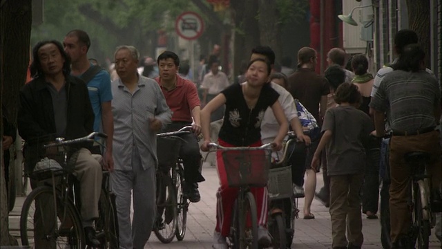 中国北京胡同拥挤的街景，人们骑着自行车视频素材