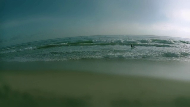 女子持有冲浪板和沿着海滩跑步，冲浪者在背景/拉古纳海滩，美国加州视频素材