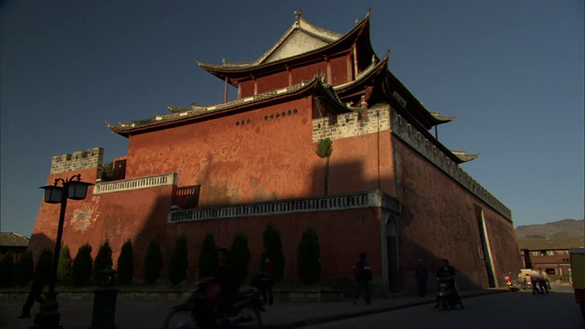 中国云南微山的WS LA寺庙在傍晚的阳光下，前景街道上的交通视频素材