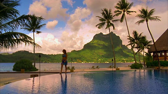 大田马努山(Mount Otemanu)在博拉博拉岛(Bora Bora)度假村无限泳池边的女子视频素材