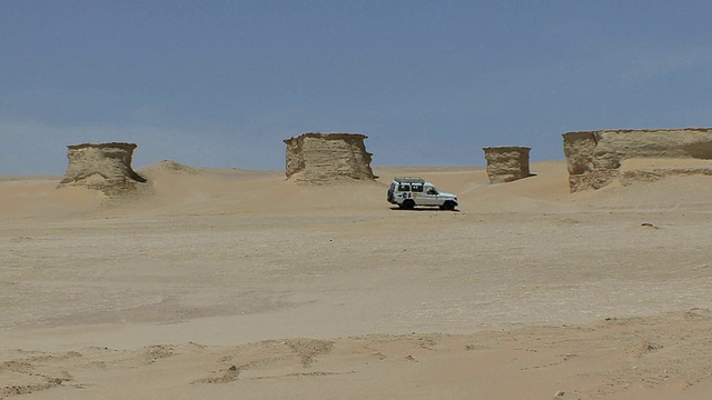 在埃及Qarun地区Fayoum地区Qarun湖岸边的沙漠岩层中行驶的越野车辆视频素材